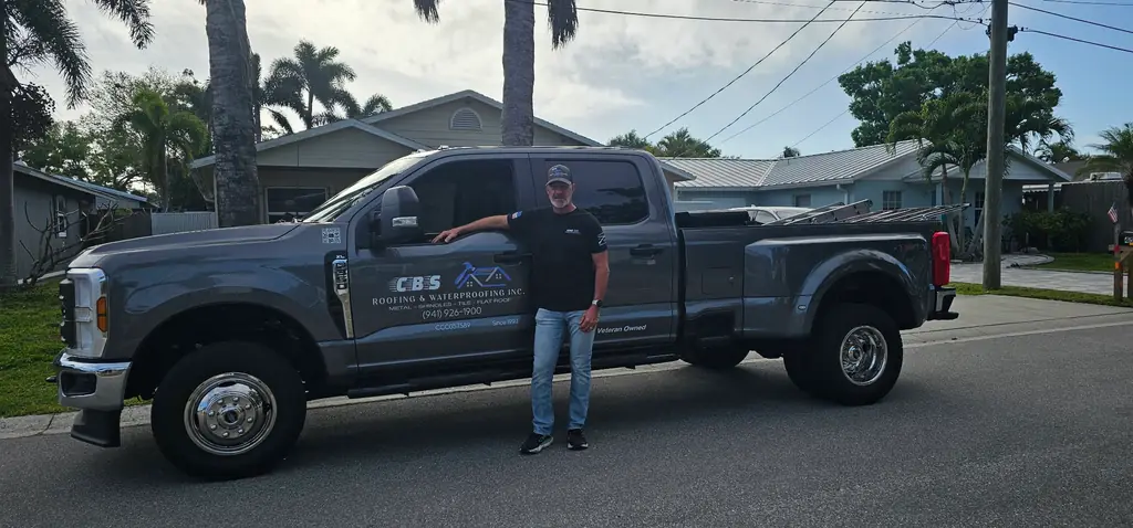 Brent Yoder, owner of CBS Roofing and Waterproofing, standing beside the company truck in Sarasota